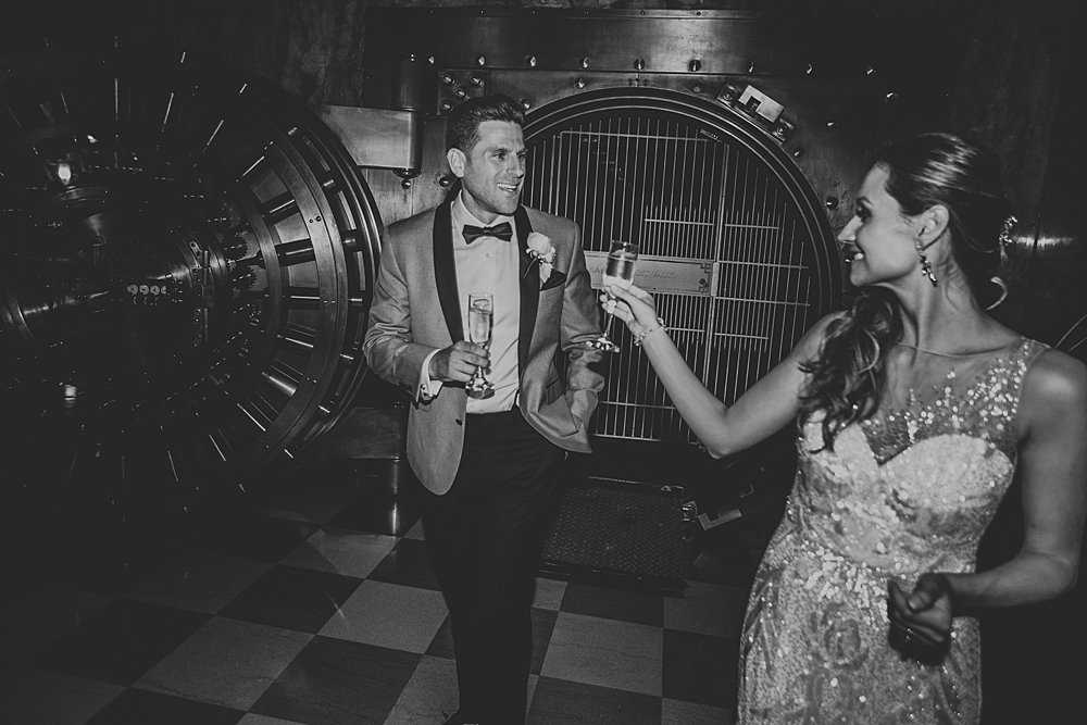 modern-day traditional romance, bride and groom toasting in the bank vault, miami wedding at the Alfred I Dupont Building