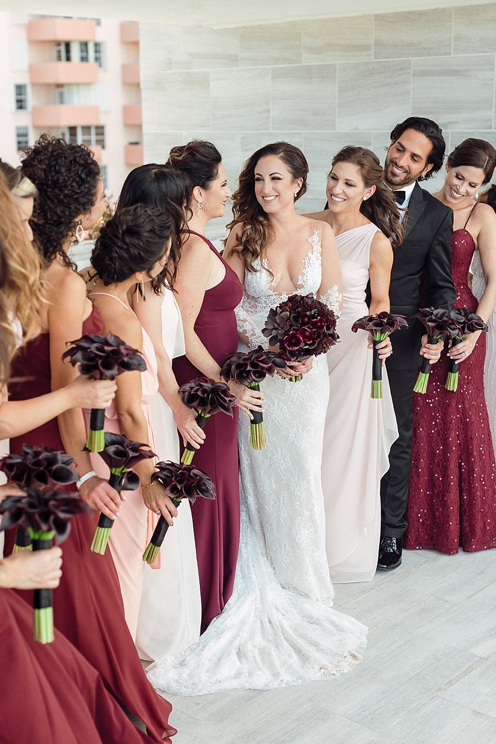 This moody and eclectic wedding at the historical DuPont Building in Miami, Florida is sure to make you swoon. | Bride and bridesmaids looking at each other
