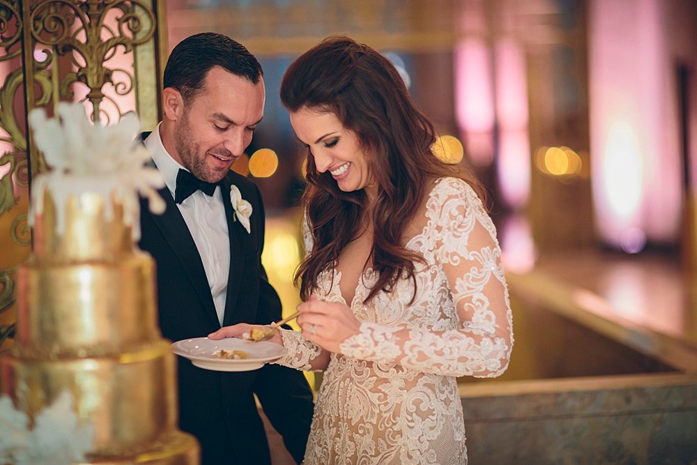 Bride and groom enjoying cake during their reception at the Historic Alfred I DuPont building in Miami, Florida
