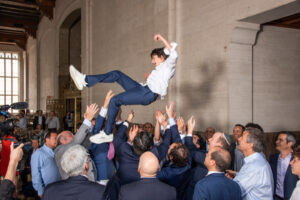 Boy in a Bar Mitzvah being thrown up by family and friends