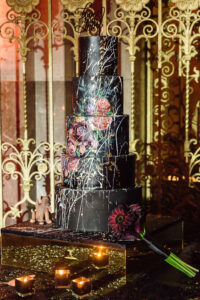 Black wedding cake featuring 2025 wedding cake trends like gold accents